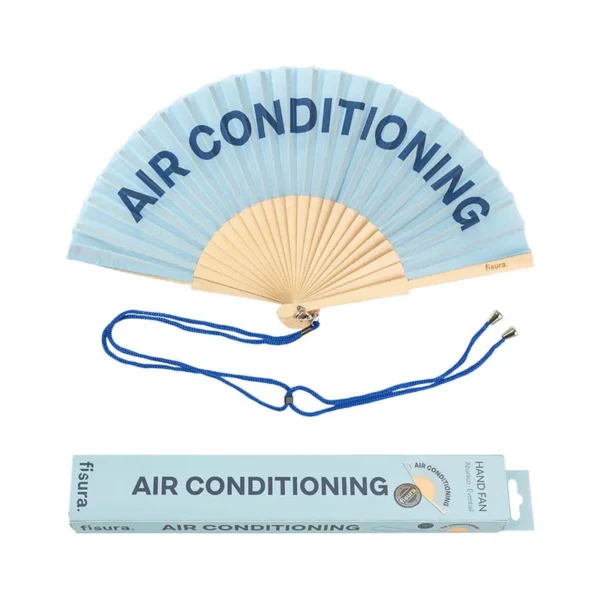Ventaglio pieghevole azzurro cielo con stecche in legno chiaro. Sul tessuto è stampata in blu scuro la frase 'AIR CONDITIONING'. Un cordino blu scuro è posizionato sotto il ventaglio, accanto alla sua scatola di imballaggio coordinata che riporta la stessa frase e il logo 'fisura'