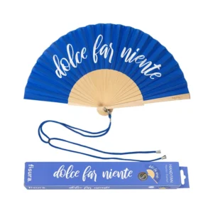 Ventaglio pieghevole blu intenso con stecche in legno chiaro. Sul tessuto blu è stampata in bianco la frase 'dolce far niente'. Un cordino blu è appoggiato sotto il ventaglio, accanto alla sua scatola di imballaggio coordinata che riporta la stessa frase e il logo 'fisura'