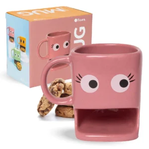 "Tazza in ceramica rosa di forma squadrata con due grandi occhi bianchi, lunghe ciglia nere e una fessura rettangolare per i biscotti alla base. Dietro la tazza ci sono alcuni biscotti con gocce di cioccolato e, sulla sinistra, la scatola di cartone della tazza con la scritta 'fisura. MUG COOKIE' e un'immagine di tazze di vari colori."