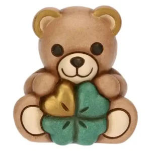 Mini statuetta Thun a forma di orsetto Teddy di colore marrone chiaro che tiene un quadrifoglio verde e oro.