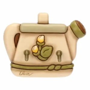 Portastrofinacci THUN in ceramica color crema a forma di annaffiatoio stilizzato, decorato con due boccioli di fiori e foglie verdi, con una fascia verde e due ganci dorati alla base.
