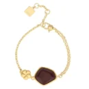 Bracciale dorato Thun con una catena sottile, un elemento centrale con una pietra ceramica irregolare color bordeaux e un piccolo fiore dorato.