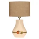 Lampada da tavolo THUN grande in ceramica color crema con paralume beige, decorata con una coccinella rossa e fiori bianchi alla base.