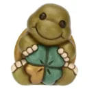 Mini statuetta Thun a forma di tartaruga verde e marrone che tiene un quadrifoglio.