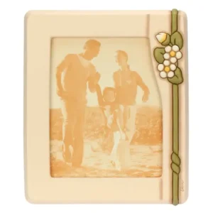 Portafoto THUN maxi in ceramica color crema con cornice rettangolare, decorato con una fascia verde verticale, fiori bianchi e un bocciolo, con una foto di famiglia visibile.