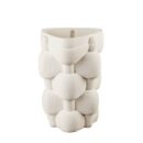 Vaso moderno de L'Oca Nera di colore bianco avorio, con una forma astratta composta da elementi sovrapposti e una texture superficiale a coste orizzontali.