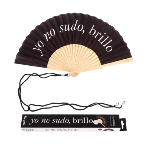 Ventaglio pieghevole nero con stecche in legno chiaro. Sul tessuto nero è stampata in bianco la frase 'yo no sudo, brillo'. Un cordino nero è appoggiato sotto il ventaglio, accanto alla sua scatola di imballaggio che riporta la stessa frase e il logo 'fisura